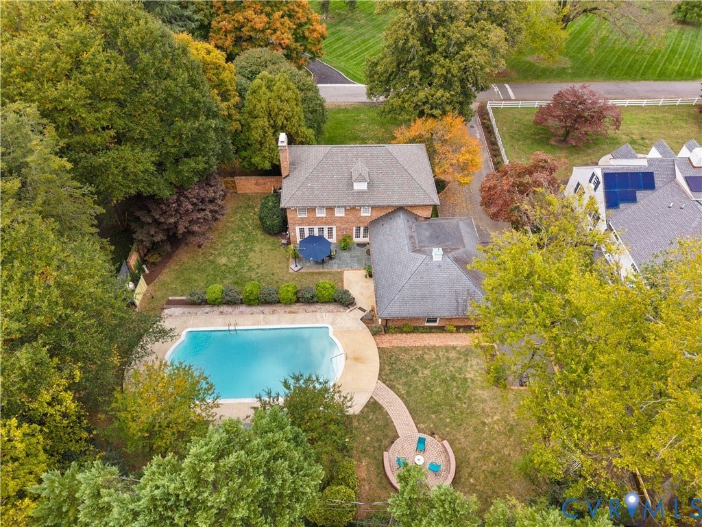1203 Rothesay Circle, Windsor Farms, Richmond, VA 23221 Aerial view featuring a brick exterior residence, in-ground swimming pool, stone patio, brick-paved walkway, and a circular fire pit area set within a wooded lot