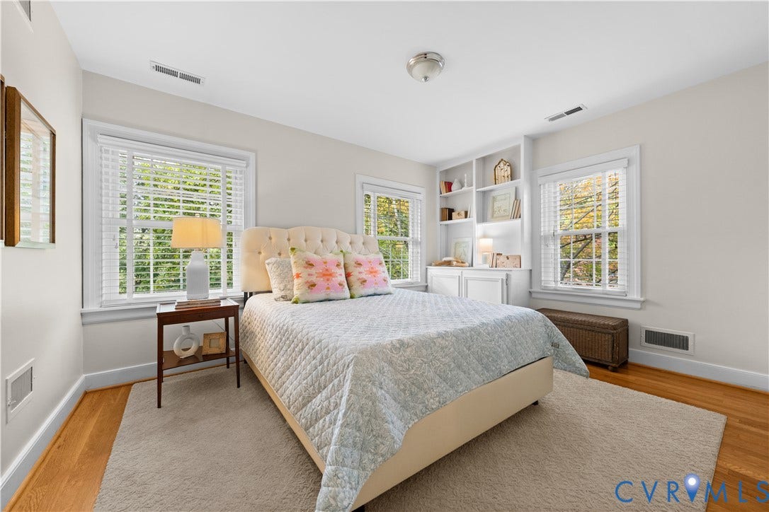 1203 Rothesay Circle, Windsor Farms, Richmond, VA 23221 Neutral-toned room featuring hardwood flooring, built-in white shelving, and multiple windows with white wood-slat blinds