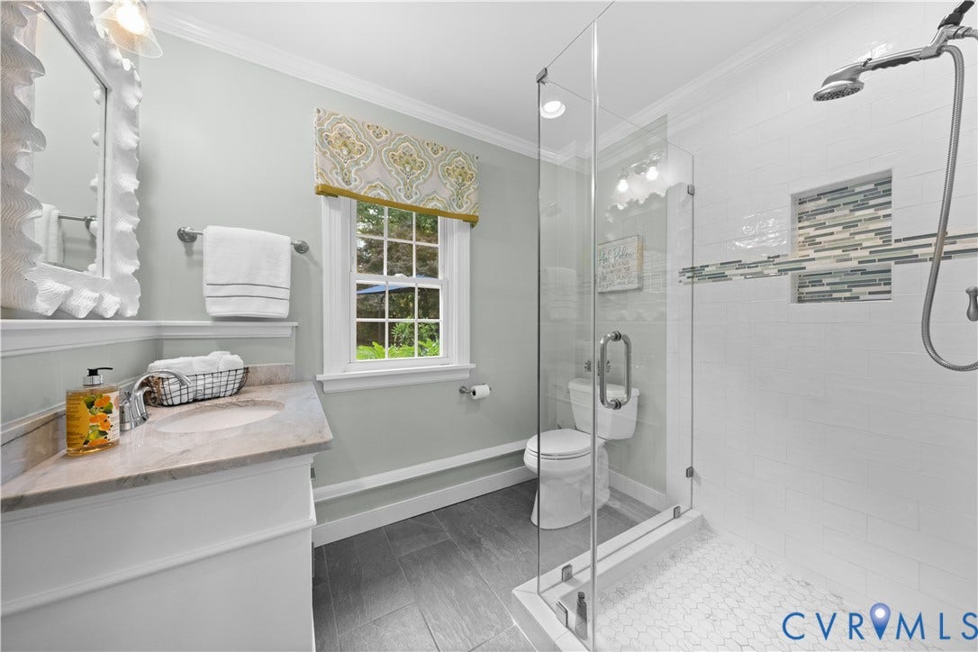 1203 Rothesay Circle, Windsor Farms, Richmond, VA 23221 Bathroom featuring gray tile flooring, a stone-surfaced vanity with an integrated sink, a glass-enclosed walk-in shower with white subway tiling, and a recessed decorative tile niche