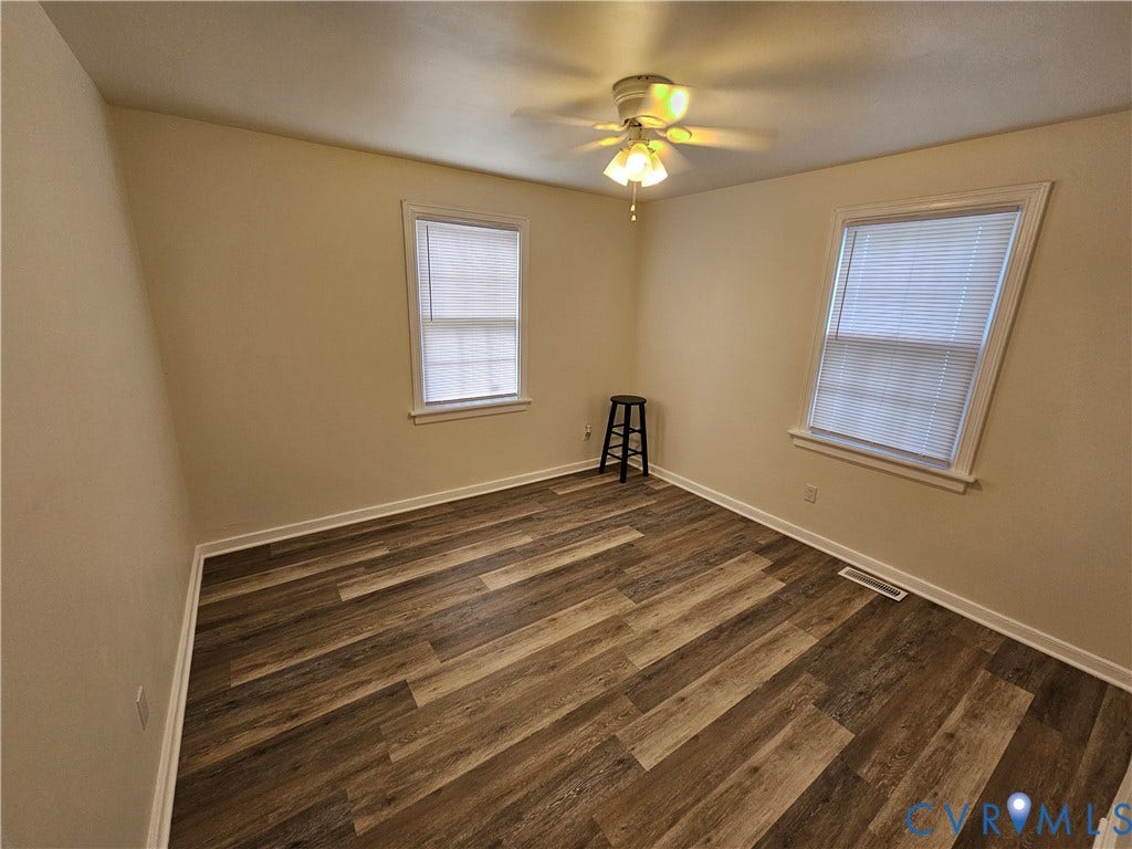 1112 E 15th Street, Richmond, VA 23224 Neutral interior space featuring wood-finish flooring, two multi-pane windows, and a ceiling-mounted light fixture with integrated fan