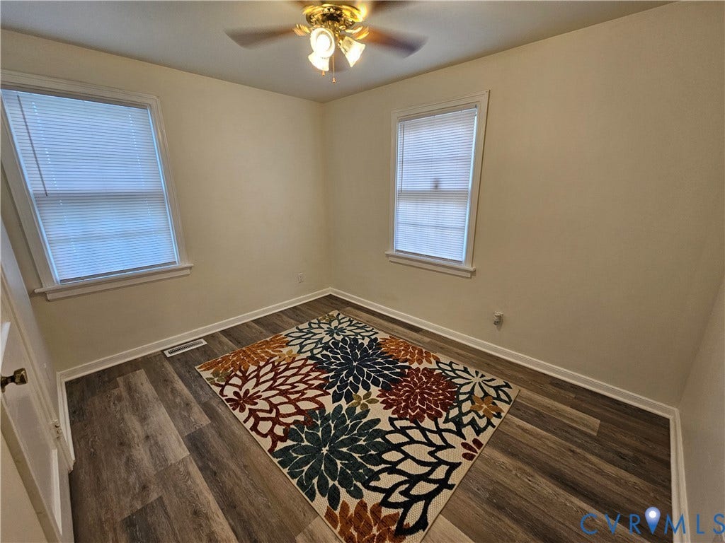 1112 E 15th Street, Richmond, VA 23224 Interior room featuring wood-finish flooring, two dual-pane windows with horizontal blinds, and a ceiling-mounted light fixture with a central fan