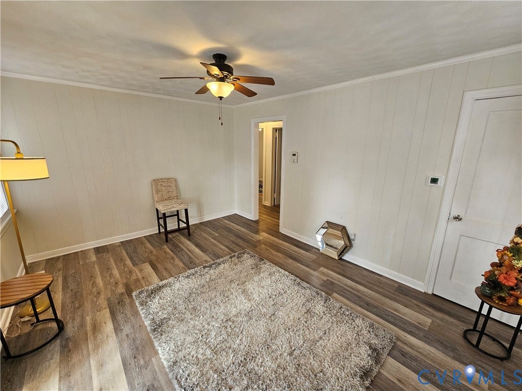 1112 E 15th Street, Richmond, VA 23224 Neutral-toned vertical paneling, wood-finish flooring, and ceiling-mounted fan with integrated light fixture