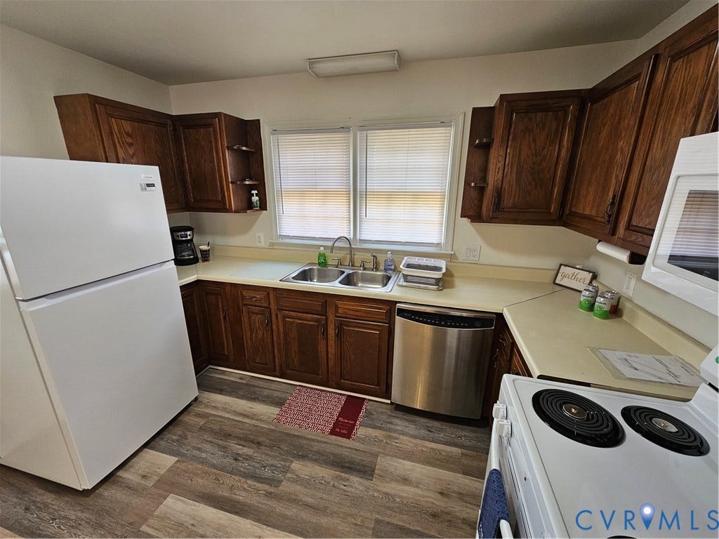 1112 E 15th Street, Richmond, VA 23224 Kitchen featuring wood-finish cabinetry, stainless steel dishwasher, double-basin sink, and wood-finish flooring