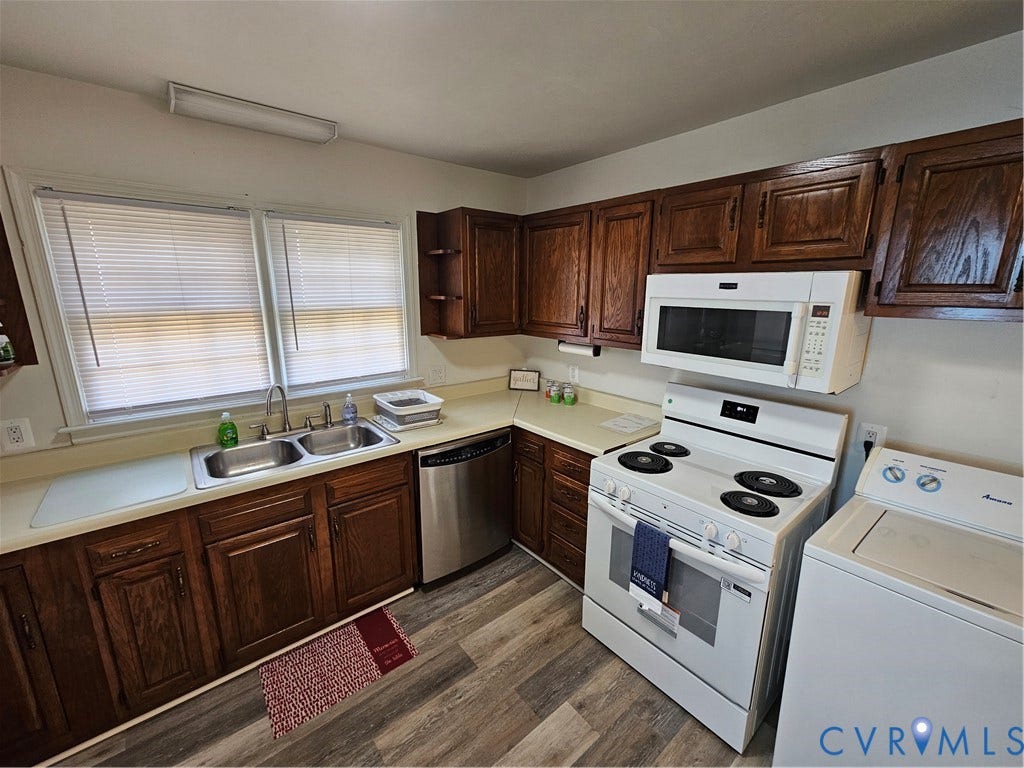 1112 E 15th Street, Richmond, VA 23224 Kitchen featuring stained wood cabinetry, wood-finish flooring, dual-basin stainless steel sink, and white appliances