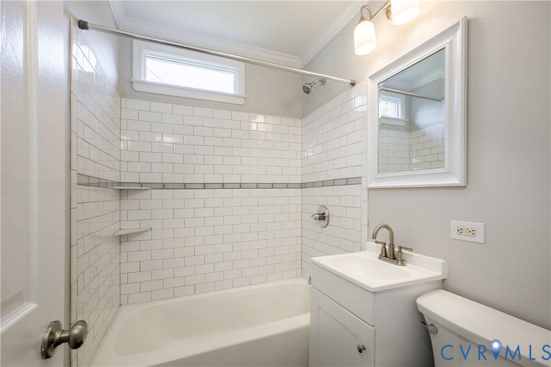 1010 E 17th Street, Oak Grove, Richmond, VA 23224 Bathroom featuring white subway tile shower surround with integrated shelving, white pedestal vanity, chrome-finish hardware, and crown molding