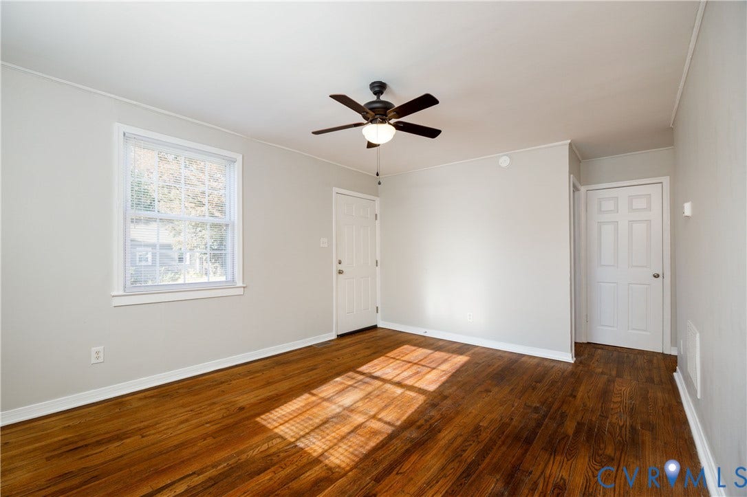 1010 E 17th Street, Oak Grove, Richmond, VA 23224 Room featuring wood-finish flooring, a multi-pane window, a ceiling-mounted light fixture with fan, and two interior doors