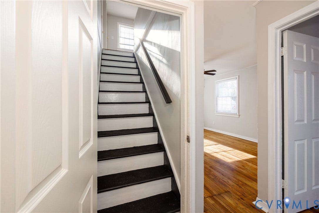 1010 E 17th Street, Oak Grove, Richmond, VA 23224 Staircase with high-contrast painted treads, wood-finish flooring, multi-pane windows, and six-panel interior doors
