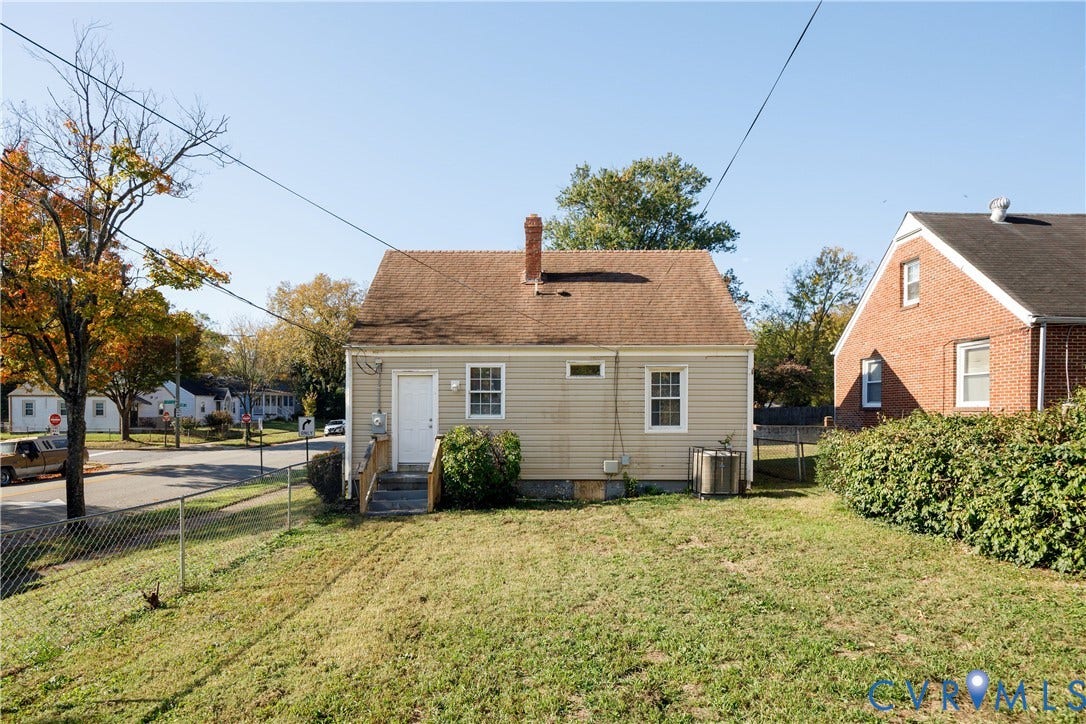 1010 E 17th Street, Oak Grove, Richmond, VA 23224 Exterior profile featuring horizontal siding, a central masonry chimney, and a rear staircase with wood railings