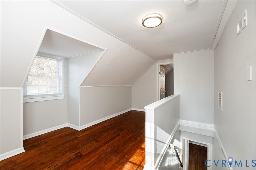 1010 E 17th Street, Oak Grove, Richmond, VA 23224 Interior space featuring wood-finish flooring, a vaulted ceiling, a multi-pane dormer window, and a wall-mounted ceiling light fixture