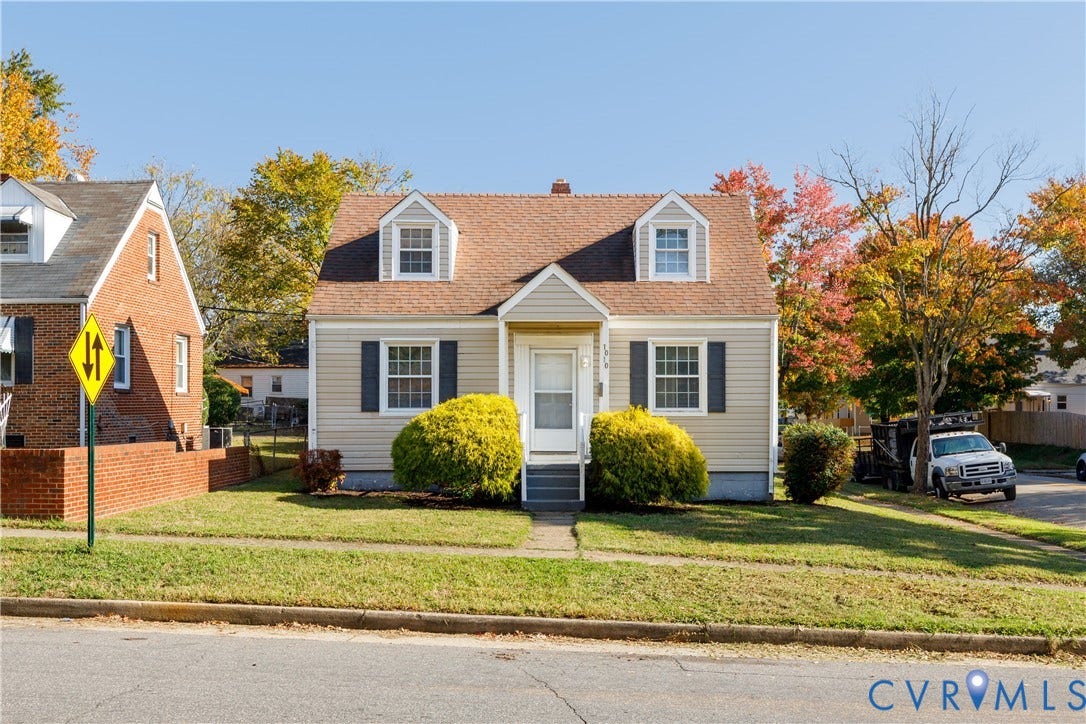 1010 E 17th Street, Oak Grove, Richmond, VA 23224 Cape Cod style exterior featuring horizontal siding, twin dormer windows, a covered front entryway, and dark window shutters