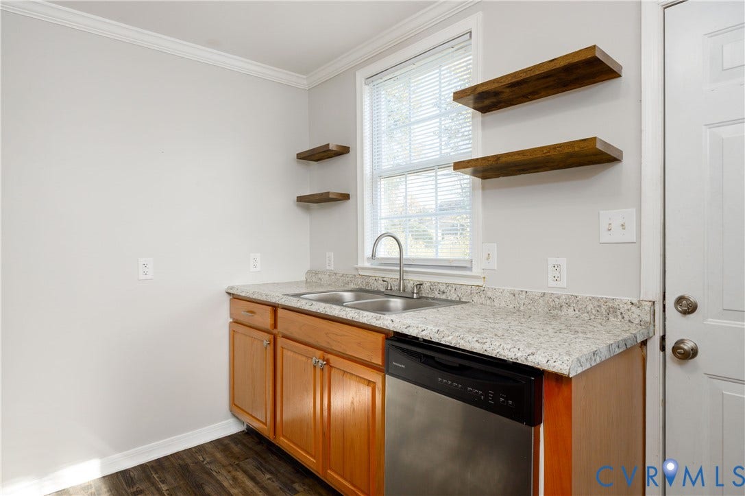 1010 E 17th Street, Oak Grove, Richmond, VA 23224 Natural wood-finish cabinetry, stone-texture laminate countertop, dual-basin stainless steel sink, built-in stainless steel dishwasher, and mounted wood shelving
