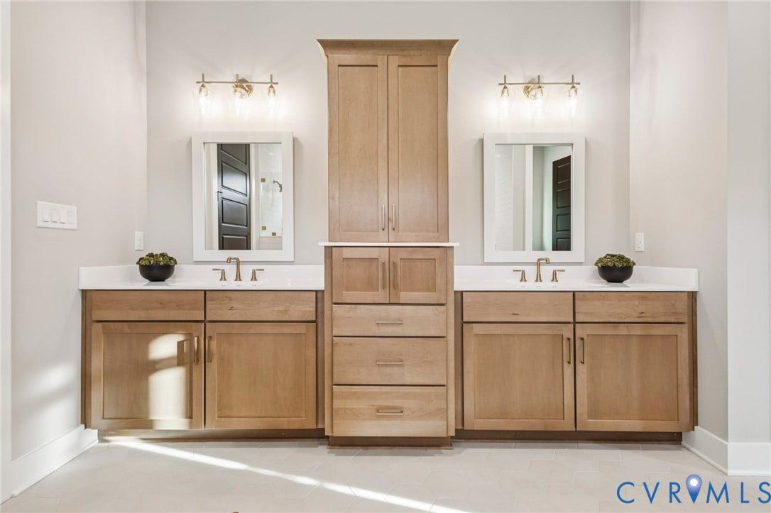9275 Topeka Road, Quinton, VA 23141 Dual vanity with light wood-finish cabinetry, white countertops, and brushed nickel fixtures