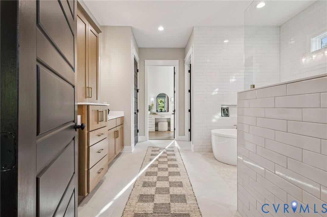 9275 Topeka Road, Quinton, VA 23141 Modern bathroom featuring a freestanding soaking tub, an expansive tiled shower with a glass enclosure, light wood cabinetry with a white countertop, and recessed lighting