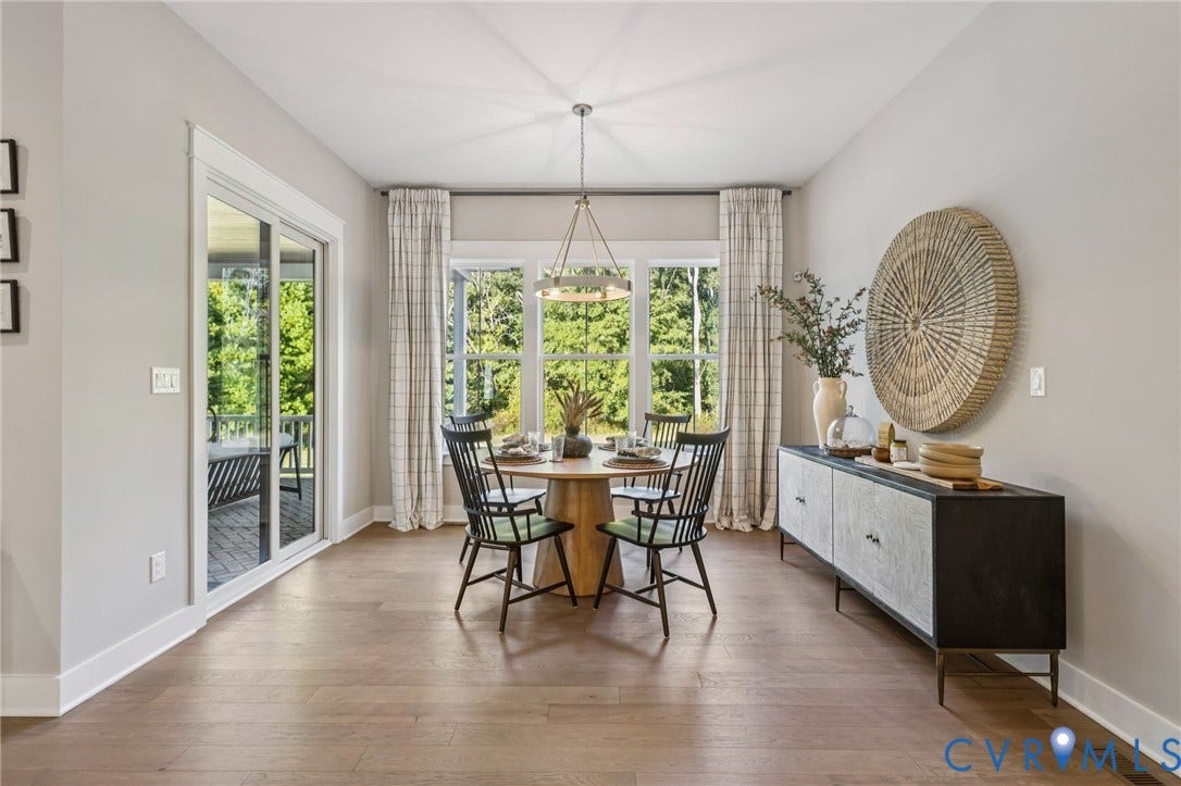 9275 Topeka Road, Quinton, VA 23141 Open-concept dining area featuring wood-finish flooring, a contemporary chandelier, and ample natural light from three large windows
