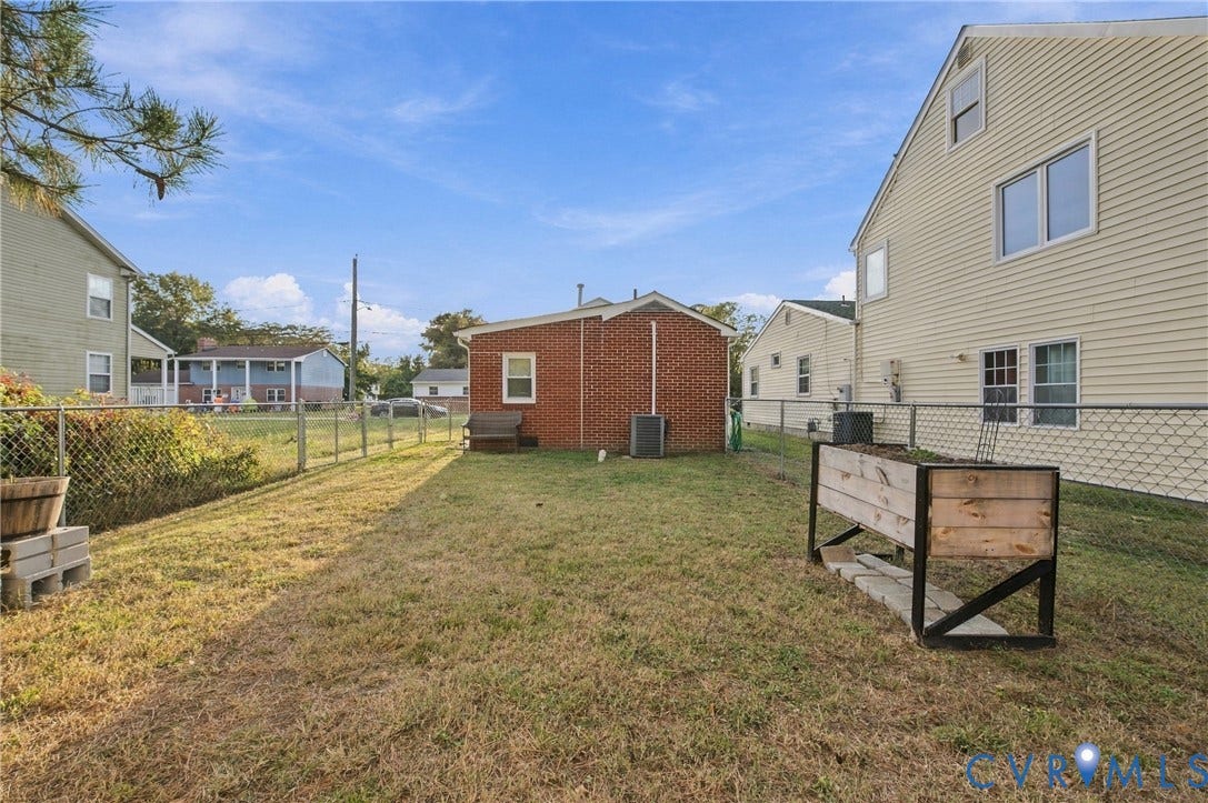 20 Victor Street, Geo Moss Estate, Hampton, VA 23669 Fenced backyard featuring a brick exterior wall, chain-link perimeter fencing, and grass lawn