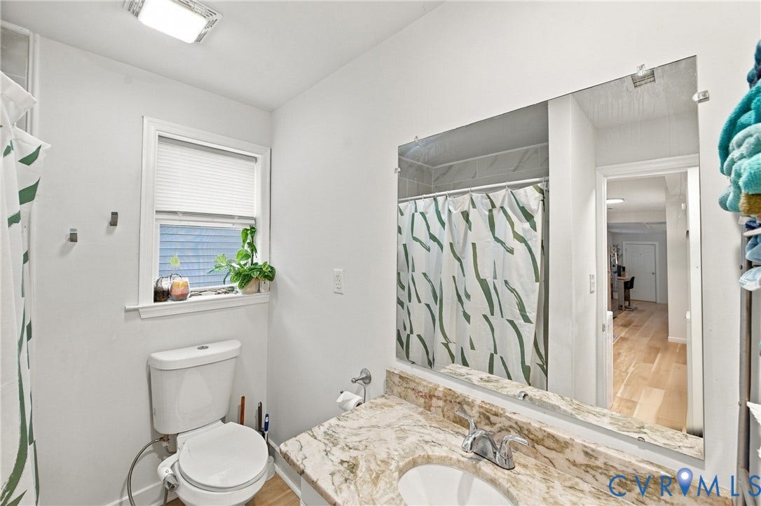 20 Victor Street, Geo Moss Estate, Hampton, VA 23669 Bathroom featuring a stone-surface vanity with an integrated basin, a large wall-mounted mirror, a tub-shower combination, and a window with horizontal blinds