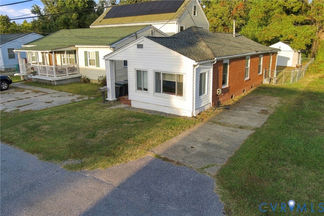 20 Victor Street, Geo Moss Estate, Hampton, VA 23669 Single-story exterior featuring a brick and vinyl facade, asphalt shingle roofing, integrated solar panels, and an attached concrete driveway