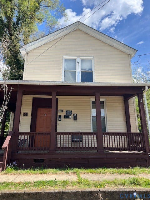 15 E 33RD Street, Richmond, VA 23225 Two-story exterior featuring light-toned horizontal siding, a covered front porch with dark-finished wooden railings and support posts, and double-hung windows
