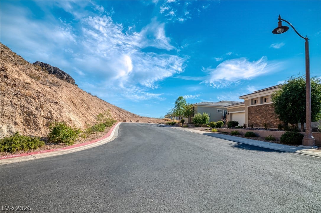 29 Porto Malaga Street, Henderson, NV 89011 A tranquil desert community with well-maintained homes nestles against a scenic hillside.