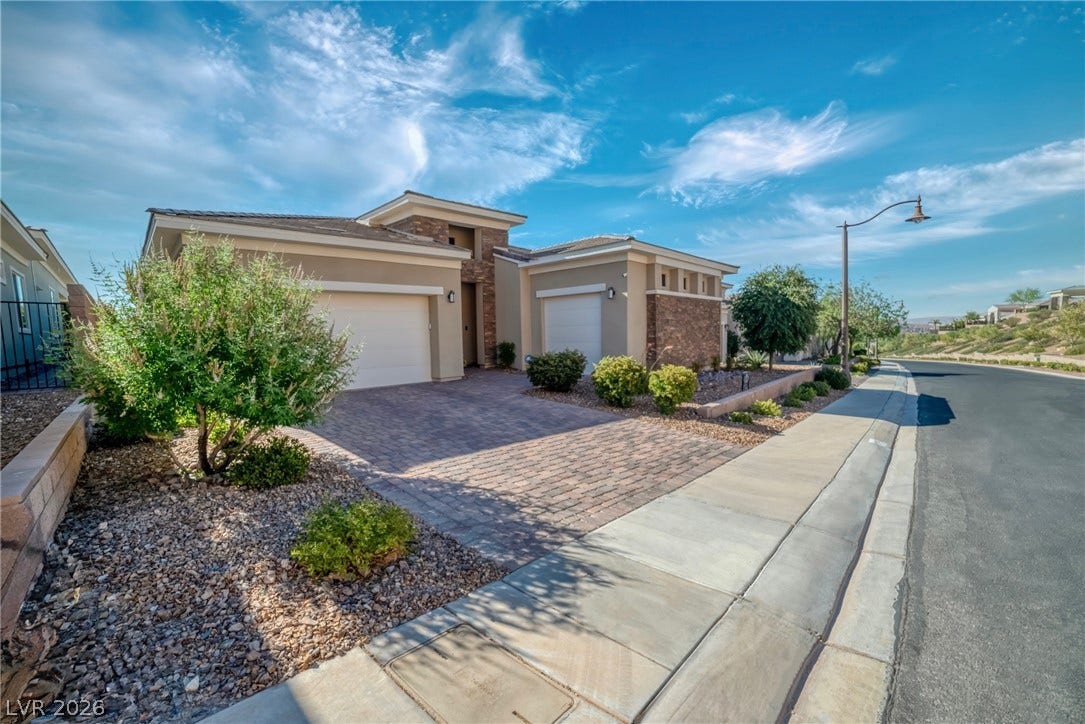 29 Porto Malaga Street, Henderson, NV 89011 A contemporary desert home with integrated garages and a paver driveway.