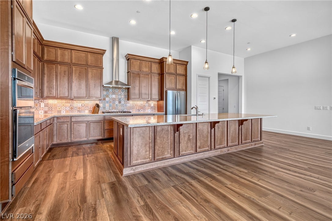 29 Porto Malaga Street, Henderson, NV 89011 A spacious culinary haven with rich cabinetry, gleaming countertops, and an inviting island for gathering.