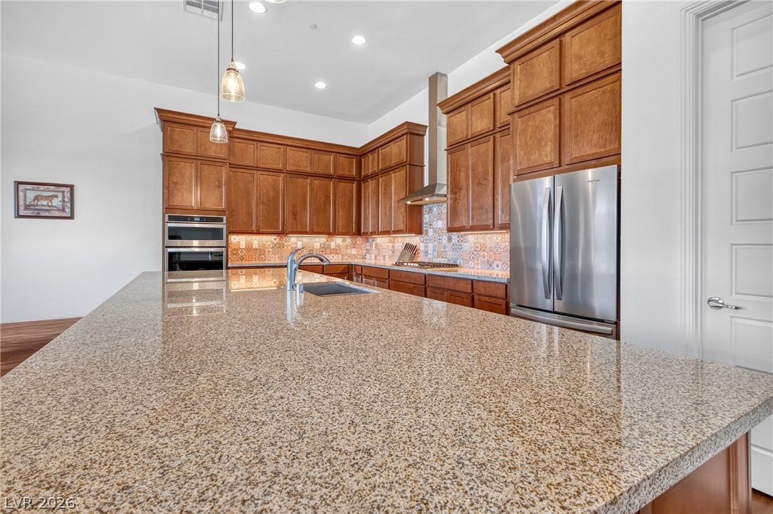 29 Porto Malaga Street, Henderson, NV 89011 Granite counters and rich wood cabinetry define this modern culinary space.
