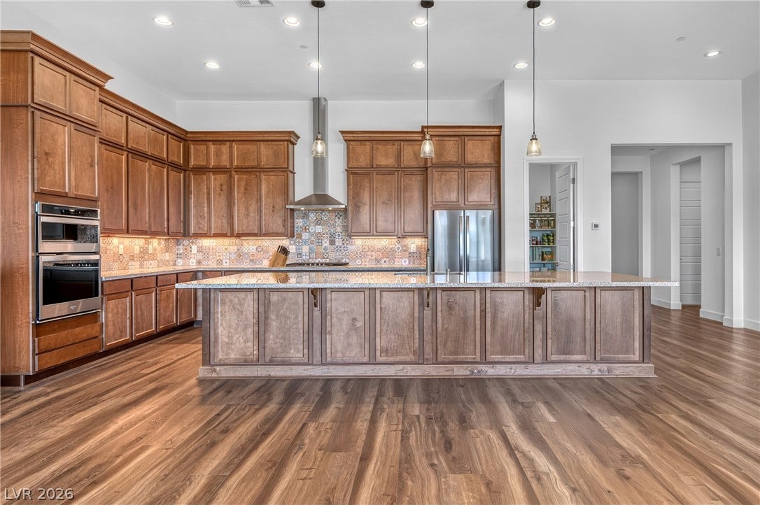 29 Porto Malaga Street, Henderson, NV 89011 A chef's kitchen featuring a large central island and gleaming hardwood floors.