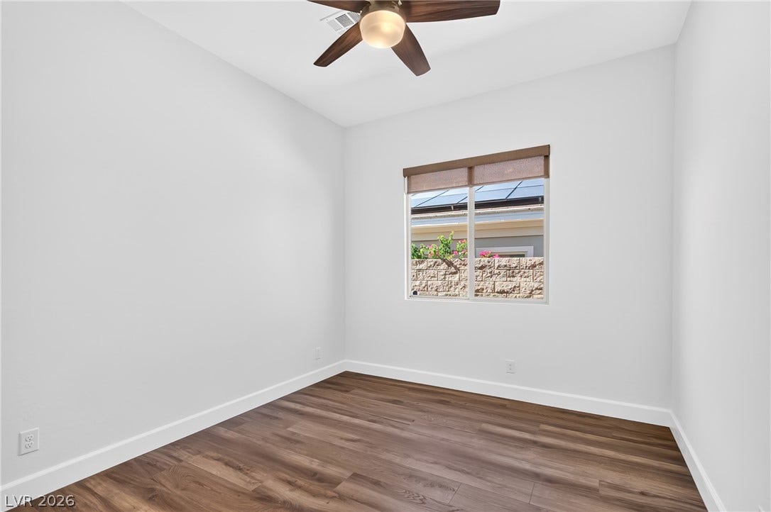 29 Porto Malaga Street, Henderson, NV 89011 An inviting room features rich wood flooring and a modern ceiling fan, offering comfort and style.