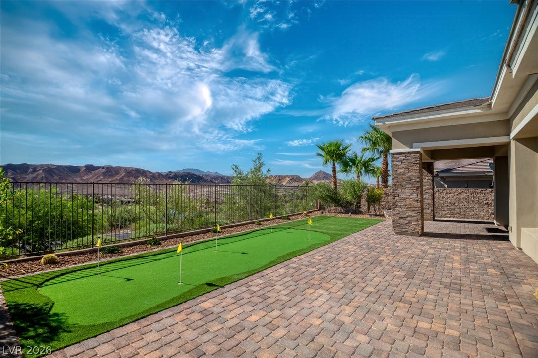 29 Porto Malaga Street, Henderson, NV 89011 An outdoor putting green provides leisurely golf practice against a backdrop of distant mountains and a blue sky.