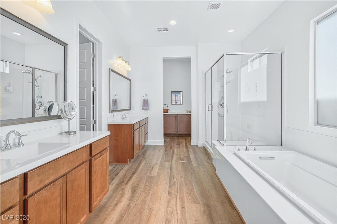 29 Porto Malaga Street, Henderson, NV 89011 A spa-inspired primary bathroom featuring a dual vanity, spacious shower, and elegant finishes for a relaxing retreat.