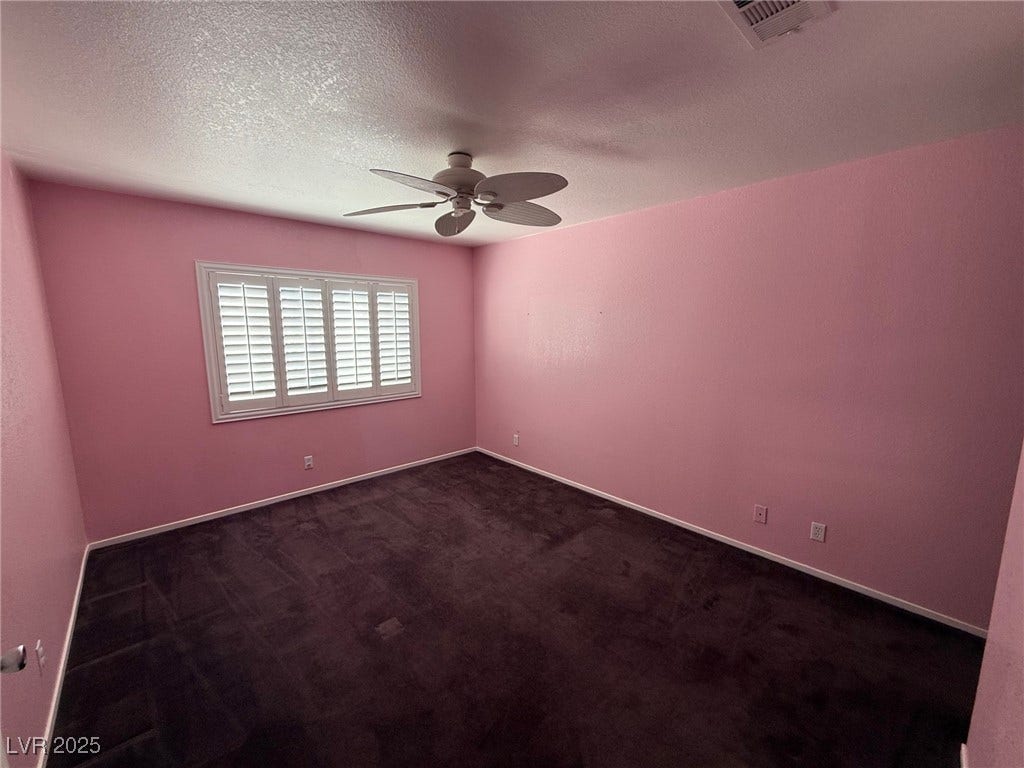 2823 Shannon Cove Drive, Henderson, NV 89074 Empty room featuring dark carpet, a textured ceiling, and a ceiling fan