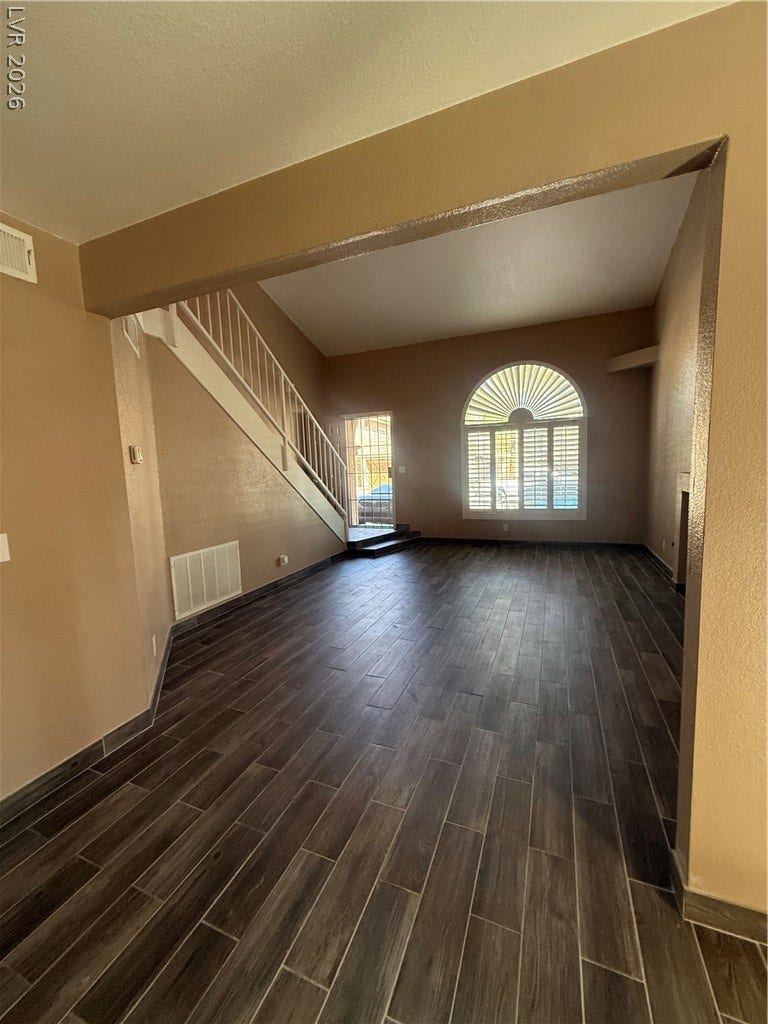 2823 Shannon Cove Drive, Henderson, NV 89074 A spacious entryway features wood-look tile flooring and a central staircase leading upstairs.