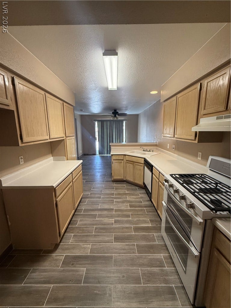 2823 Shannon Cove Drive, Henderson, NV 89074 Ample wooden cabinetry and wood-look tile flooring define this efficient kitchen space.