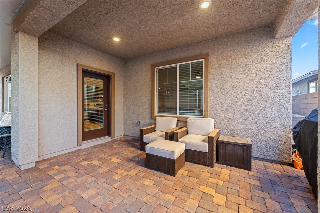 145 Rohan Crest Avenue, Henderson, NV 89011 Entertainers backyard w/ extended covered patio, dining and seating areas, spa, and retractable screen w/ projector for outdoor living and movie nights.