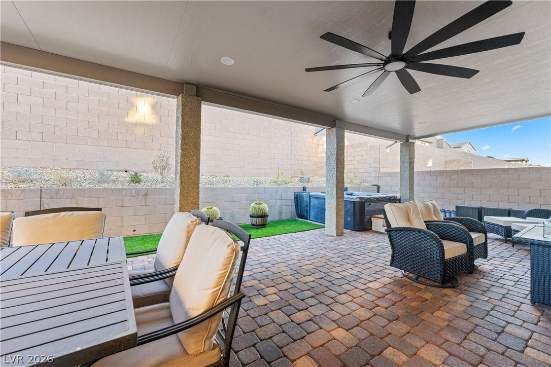 145 Rohan Crest Avenue, Henderson, NV 89011 Entertainers backyard w/ extended covered patio, dining and seating areas, spa, and retractable screen w/ projector for outdoor living and movie nights.