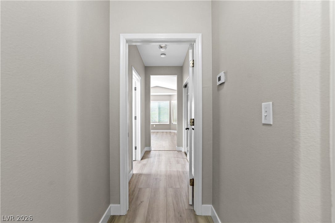 2154 High Mesa Drive, Henderson, NV 89012 A well-lit hallway with natural wood-look flooring leads to additional sun-filled spaces.