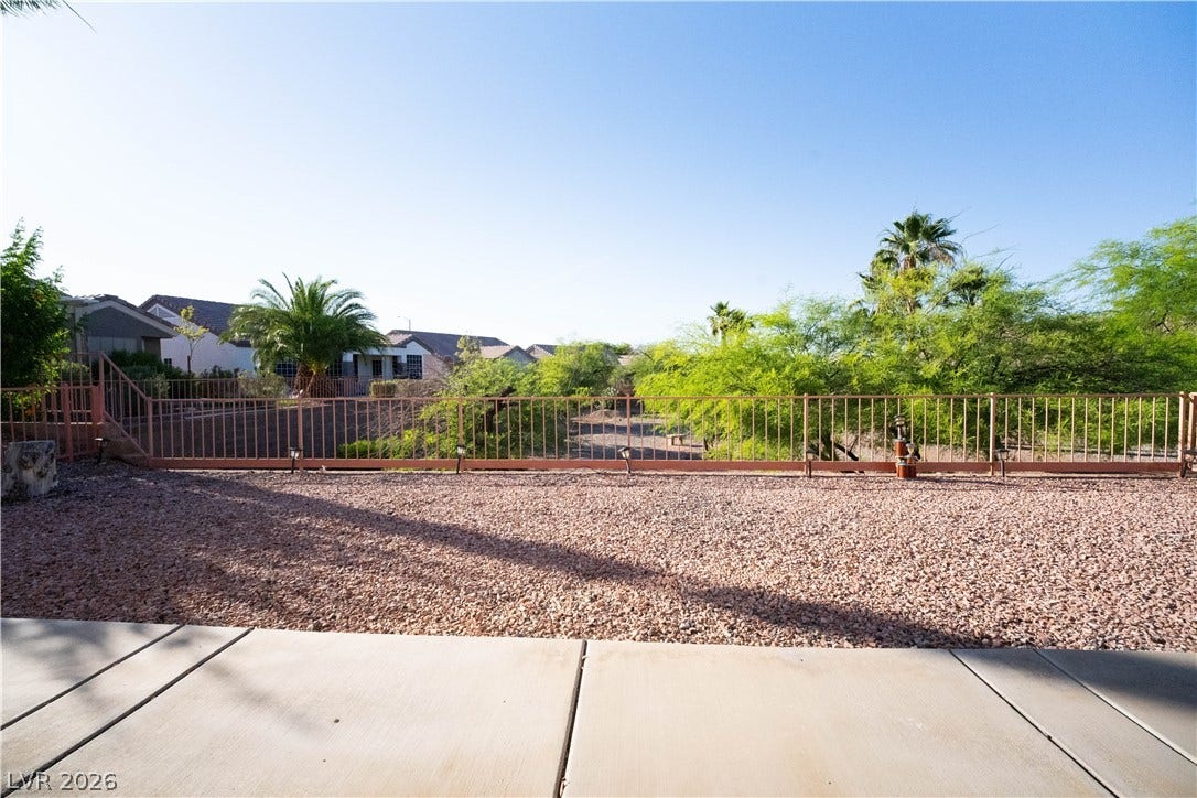 2154 High Mesa Drive, Henderson, NV 89012 This outdoor space features a gated area with vibrant trees and a clear sky.