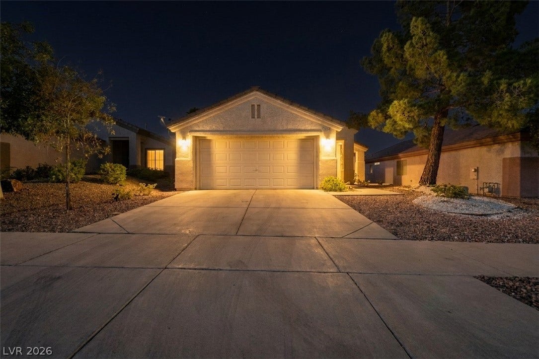 2154 High Mesa Drive, Henderson, NV 89012 Illuminated at night, this residence offers a welcoming facade with a spacious driveway.