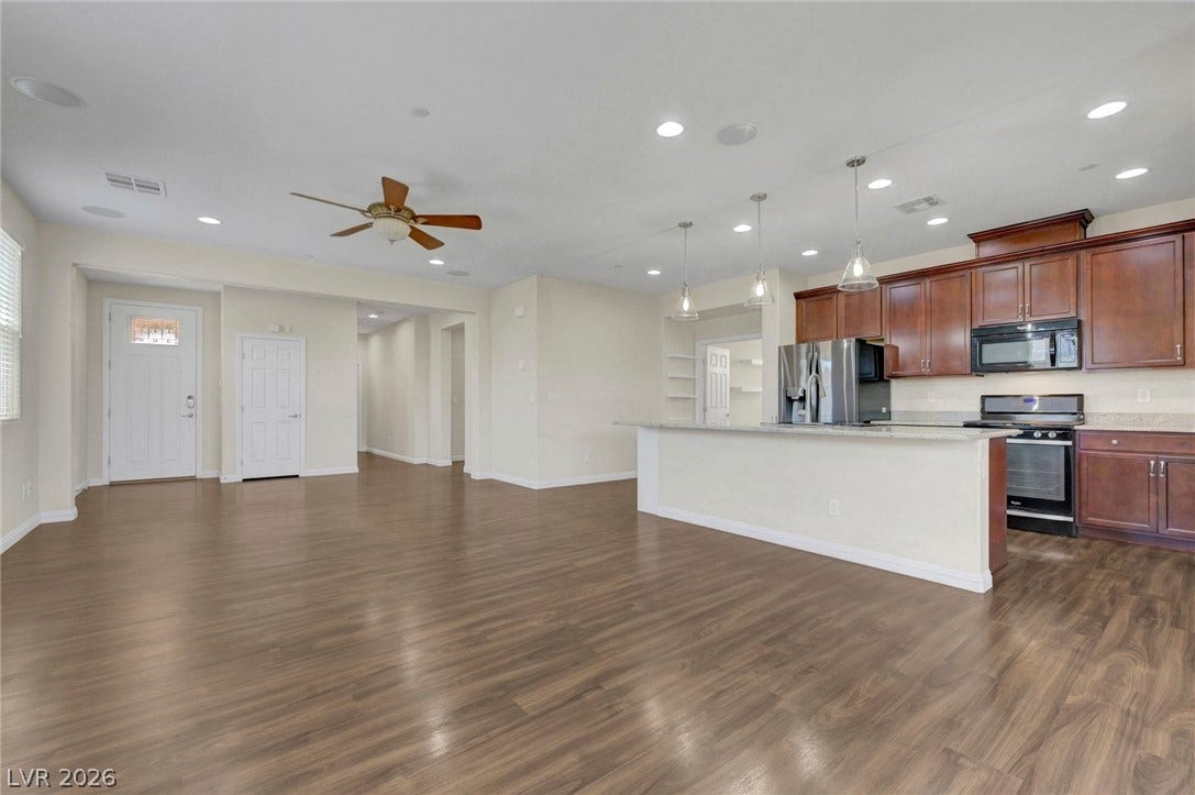 3086 Ripe Peak Lane, Henderson, NV 89044 Bright, open-concept living space features warm flooring, recessed lighting, and a modern kitchen.