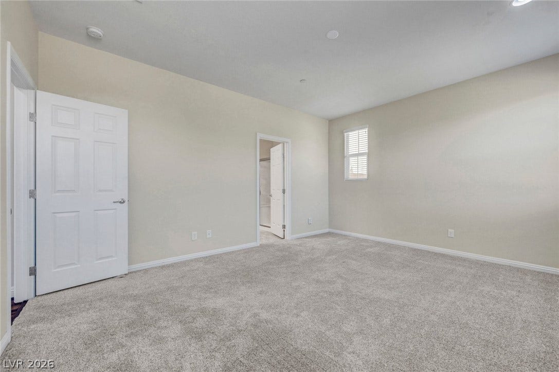 3086 Ripe Peak Lane, Henderson, NV 89044 This spacious bedroom offers comfortable carpeting and a bright window, creating a serene personal retreat.