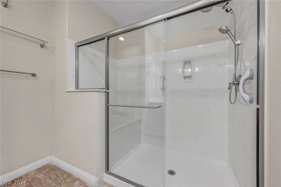 3086 Ripe Peak Lane, Henderson, NV 89044 This modern bathroom features a spacious shower with contemporary fixtures and tiled flooring.