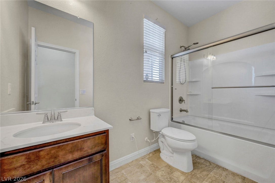 3086 Ripe Peak Lane, Henderson, NV 89044 This bathroom features a sleek vanity, a modern toilet, and a combined shower and bathtub.