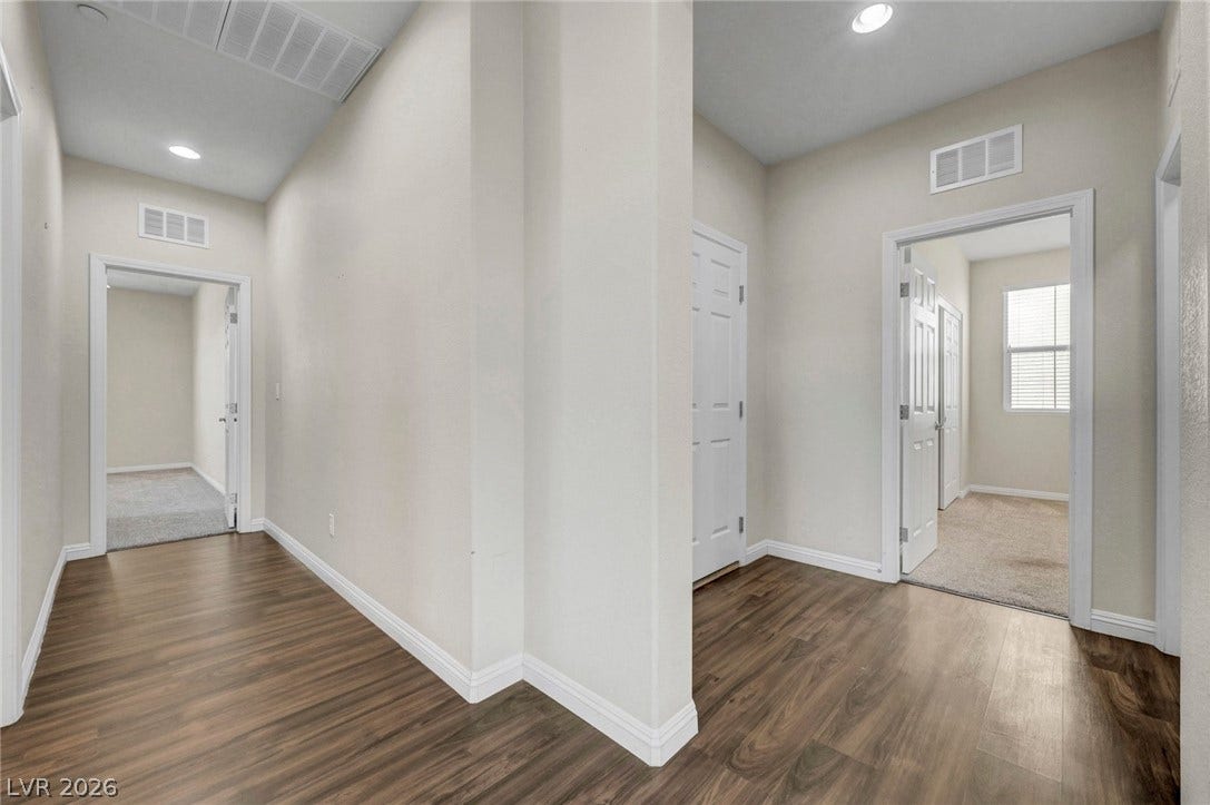 3086 Ripe Peak Lane, Henderson, NV 89044 This spacious hallway features rich hardwood flooring and leads to inviting rooms with ample natural light.