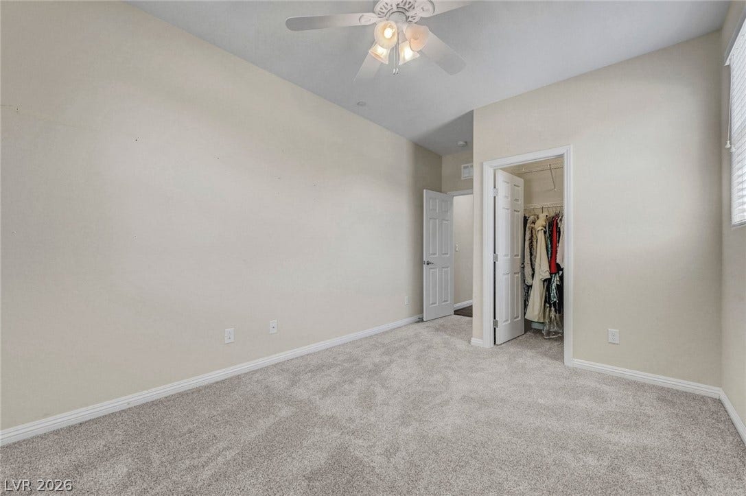 3086 Ripe Peak Lane, Henderson, NV 89044 This spacious bedroom offers comfortable carpeting and a convenient walk-in closet for ample storage.