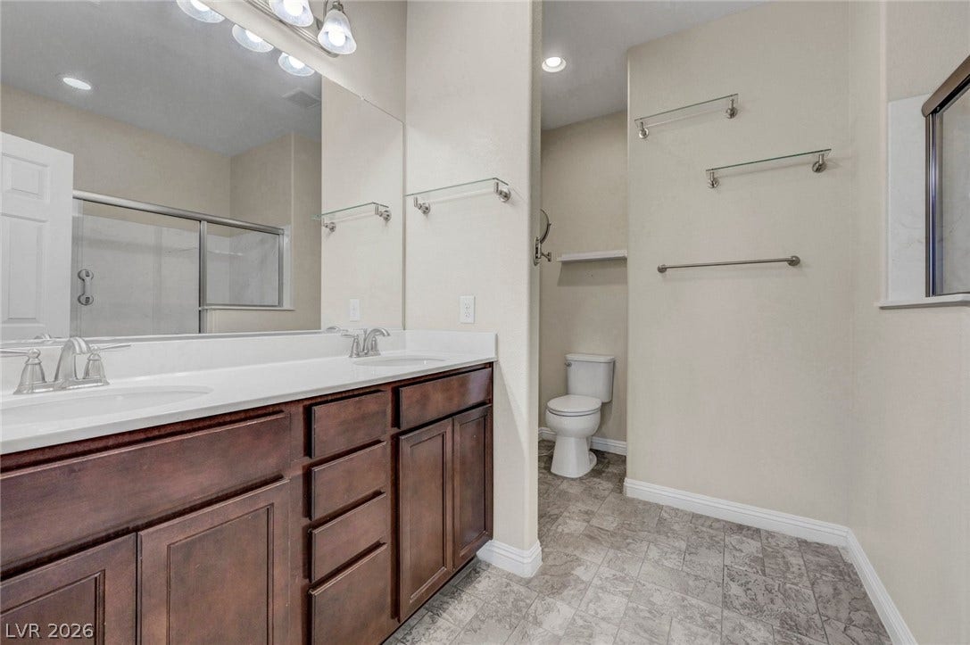 3086 Ripe Peak Lane, Henderson, NV 89044 This spacious bathroom offers a double vanity and a shower with sliding glass doors.