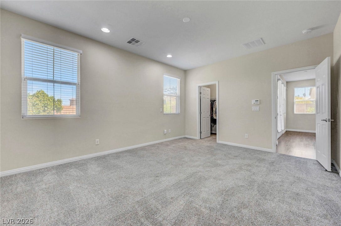 3086 Ripe Peak Lane, Henderson, NV 89044 This primary bedroom offers a serene retreat with soft carpeting and ample natural light.
