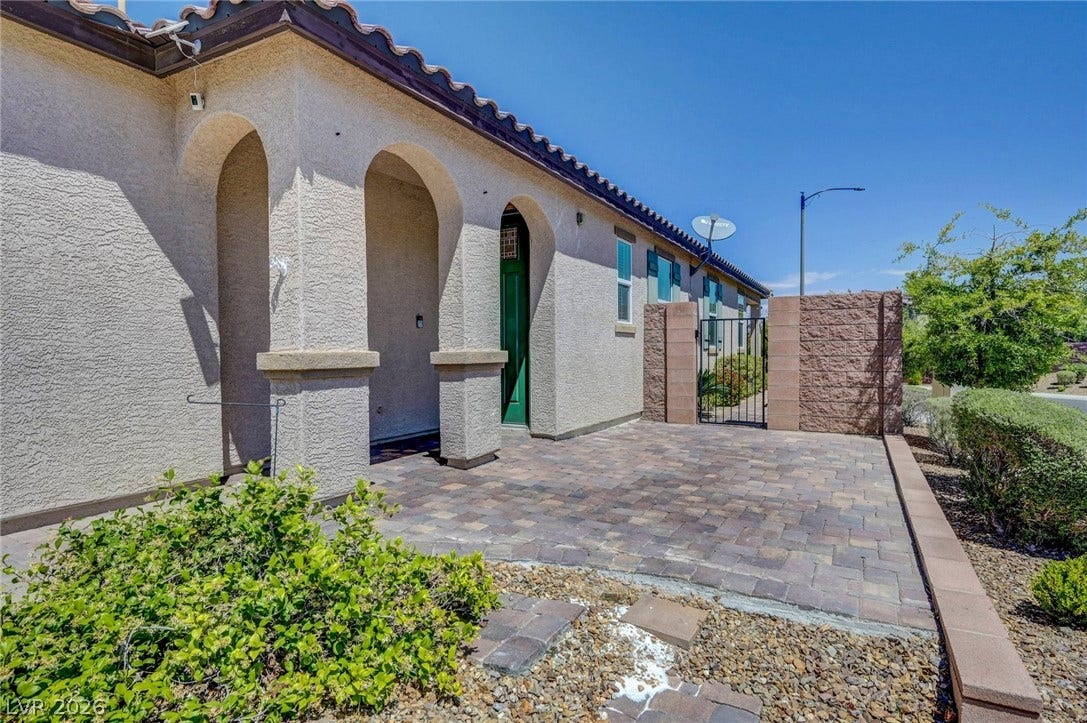 3086 Ripe Peak Lane, Henderson, NV 89044 This inviting entrance features an archway leading to a private paved courtyard with mature landscaping.