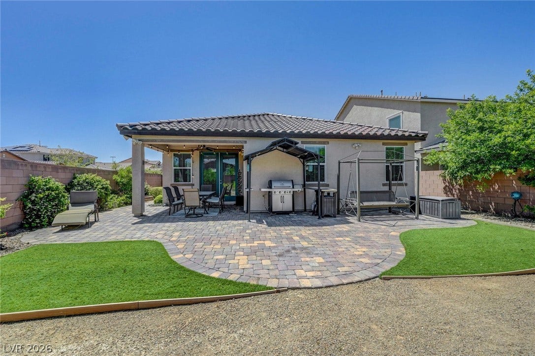 3086 Ripe Peak Lane, Henderson, NV 89044 This spacious backyard oasis features a paved patio, ideal for outdoor gatherings and relaxation.