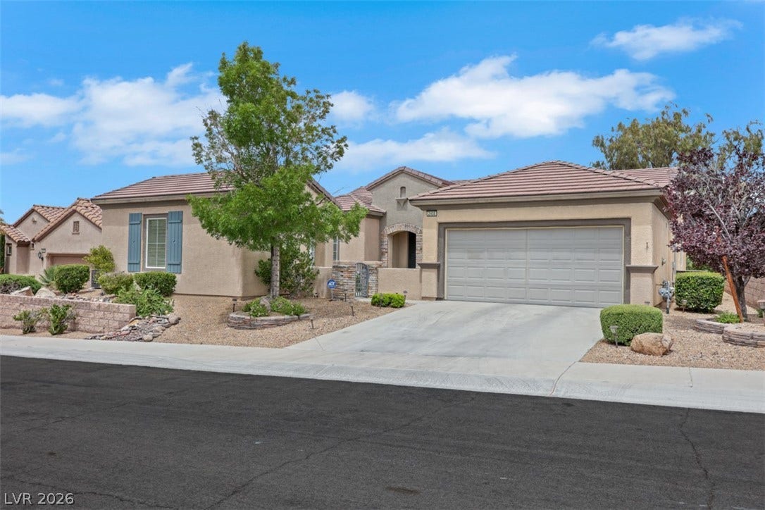 2408 Black River Falls Drive, Henderson, NV 89044 This captivating residence presents a welcoming facade with a well-maintained driveway and appealing landscaping.