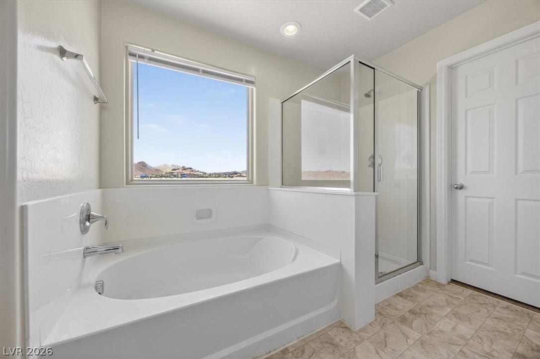 1116 Strada Cristallo, Henderson, NV 89011 An inviting soaking tub and glass-enclosed shower await in this well-appointed bathroom.